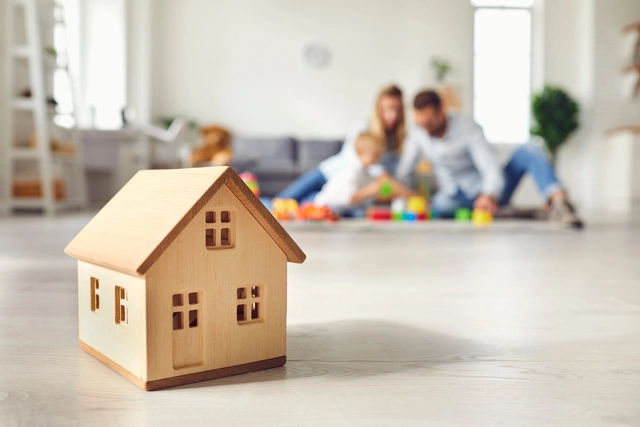 Photo d'une famille en arrière plan avec une maison en bois au  premier plan